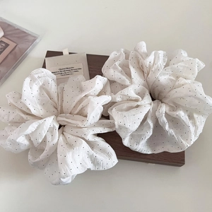 Set of white bubble cotton scrunchies with black polka dots on vintage wooden box