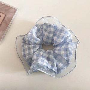 Dettaglio dell'elastico per capelli a scacchi blu e bianchi con bordo in pizzo