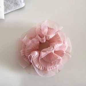 Détail de chouchou en organza rose avec volants pour des coiffures de ballet élégantes