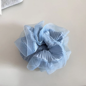 Vue détaillée du chouchou en organza bleu clair avec volants plissés et texture transparente