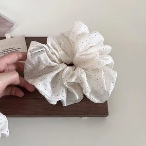 French style puffy white scrunchie with black polka dots on wooden background
