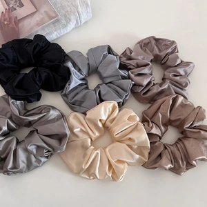 Set of 6 glossy satin scrunchies in neutral colors including black and champagne silk