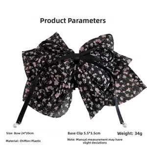 Detail of floral chiffon bow hair claw with elegant long ribbons and pearl pendants