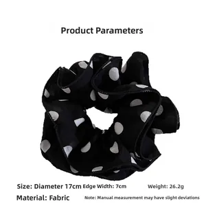 Detail view of a 17cm large polka dot scrunchie with product size and fabric parameters