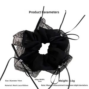 Detailed view of black lace hair scrunchie with ribbons and heart crystal detail