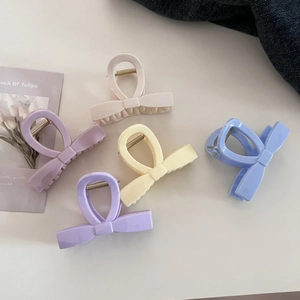Set of pastel bow hair claws in cream, lavender, yellow, and blue colors for elegant styling