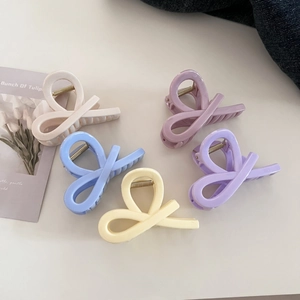 Five assorted cream-colored claw clips in various pastel shades for elegant hair styling