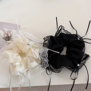 Detail view of lace ribbon scrunchies with rhinestones in black and white colors
