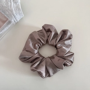 Close-up of a large satin scrunchie with rich coffee brown texture and silk sheen