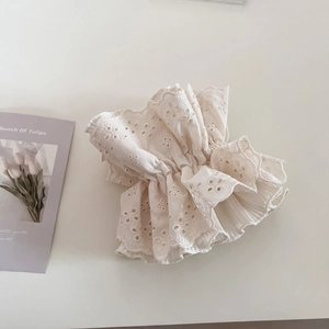 Detailaufnahme des beigen Haargummis aus Broderie Anglaise Spitze mit Faltenstruktur