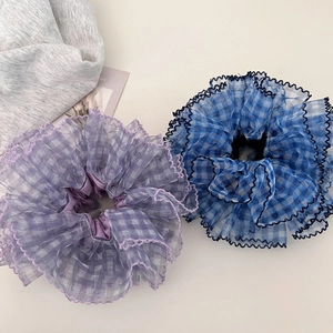 Close-up of blue and purple plaid mesh scrunchies with elegant ruffled lace edges