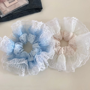 Detail of oversized blue and pink polka dot hair scrunchies with white lace edges