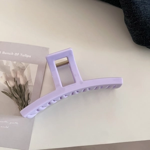 Detailed close-up of a large lavender acrylic hair claw clip with glossy finish and spring