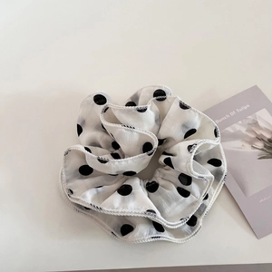 Oversized white scrunchie with black polka dots and delicate white stitching on edges