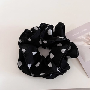 Detailed close-up of large polka dot scrunchie with layered chiffon ruffle texture