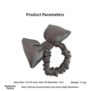 Detailed view of dark grey padded bow hair tie with satin texture and size specs