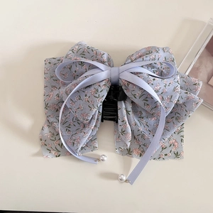 Detail of floral chiffon bow hair claw clip with ribbons and pearls in blue and pink