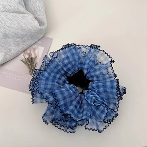 Close-up of blue gingham mesh hair scrunchie with delicate scalloped lace edges
