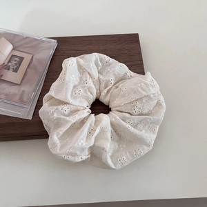 Detail of cream lace scrunchie with floral embroidery and hollow out texture