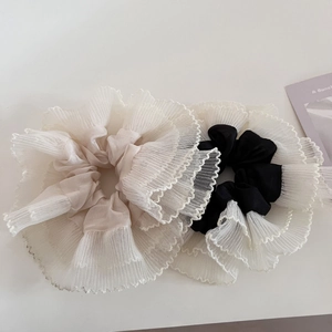 Detailed macro view of beige and black layered tulle scrunchies with pleated lace edges