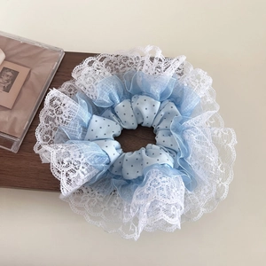 Detail of oversized light blue polka dot hair scrunchie with white lace floral trim