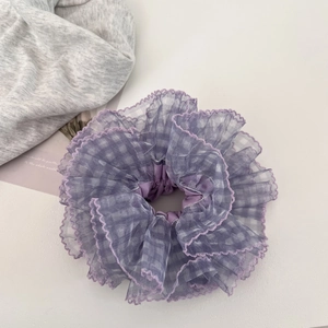 Close-up of purple mesh hair scrunchie with checkered lace pattern and ruffled design