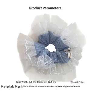 Detailed macro view of large blue mesh scrunchie with white polka dot lace ruffles