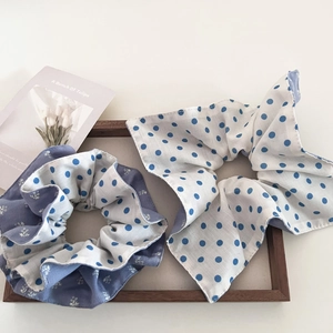 Retro blue floral and polka dot hair scrunchies set in a wooden tray background
