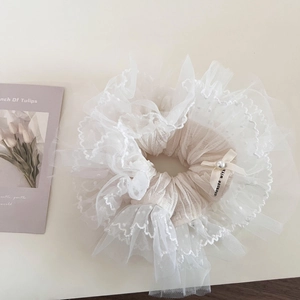 Close-up of lace scrunchie with polka dots, handmade ribbon and pearl detail