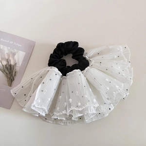 Detailed close-up of a French retro polka dot lace scrunchie with layered fabric texture