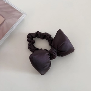 Close-up of a large satin bow scrunchie with silky smooth texture and elegant puffy design