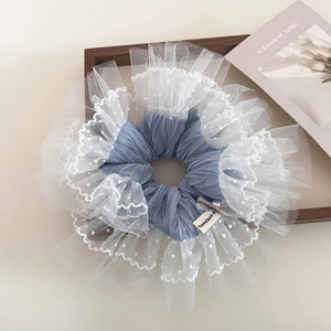 Detail of blue ruffled hair scrunchie with white polka dot lace, bow, and pearl accent