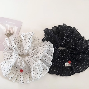 Close-up of polka dot chiffon hair scrunchies with handmade labels and heart buttons