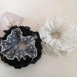 Close-up of black and white tulle scrunchies with polka dot lace and mesh texture