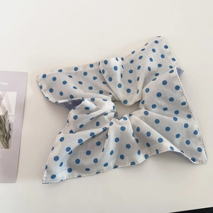 Close-up of blue polka dot pattern hair scrunchie with detailed stitching on fabric