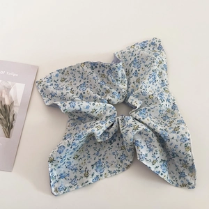 Close-up of a blue and yellow floral scrunchie with soft cotton fabric texture