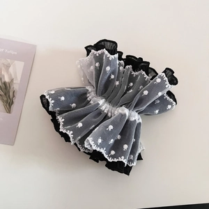 Detail of layered black and white tulle lace hair tie with delicate floral embroidery