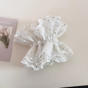 Close-up of white mesh hair scrunchie with black polka dots and floral lace embroidery