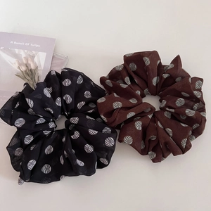 Elegant oversized brown and black polka dot scrunchies in soft chiffon on a neutral surface