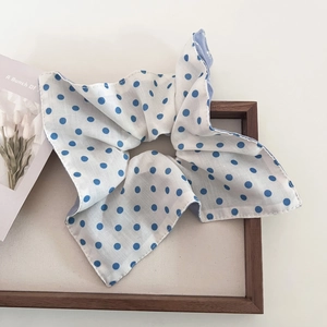 Close-up of blue polka dot white fabric hair scrunchie with clean stitching detail
