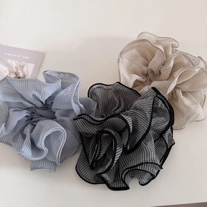 Detailed view of light blue, black, and beige gingham chiffon ruffled scrunchies