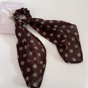 Vintage brown polka dot hair scrunchie with long ribbons on a clean white background