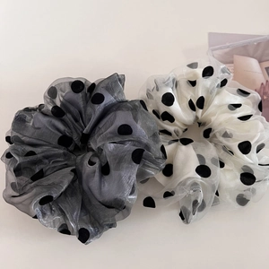 Detail of large double-layer mesh polka dot scrunchies in gray and beige colors