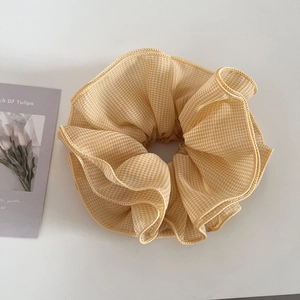 Detailed view of yellow gingham chiffon hair scrunchie with layered ruffle edge design