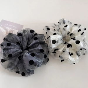 Detailed view of layered organza polka dot hair scrunchies in grey and beige