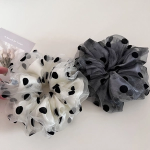 Close-up of dual-layer mesh scrunchies with black polka dots in cream and grey organza