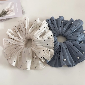 Close-up of pearl embellished polka dot hair scrunchies in cream and blue chiffon fabric