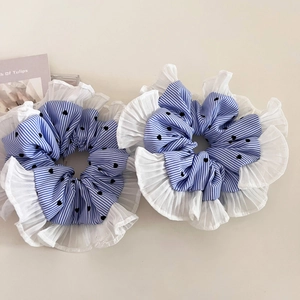 Close-up of blue striped scrunchies with black heart patterns and white lace pleats