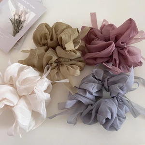 Detail showing various colors of sheer organza scrunchies with elegant long ribbons