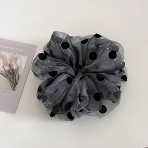 Detail of grey polka dot organza hair scrunchie with soft mesh texture and flocking